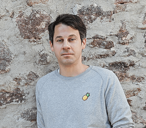 Foto: Radiomoderator Johannes Sassenroth lehnt an einer Mauer