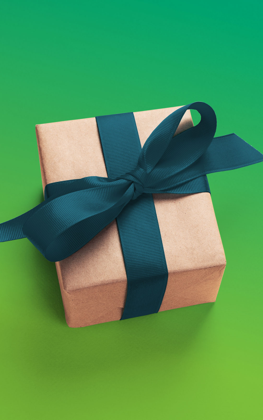 Foto: Geschenkbox aus braunem Karton mit grünem Geschenkband auf grünem Hintergrund